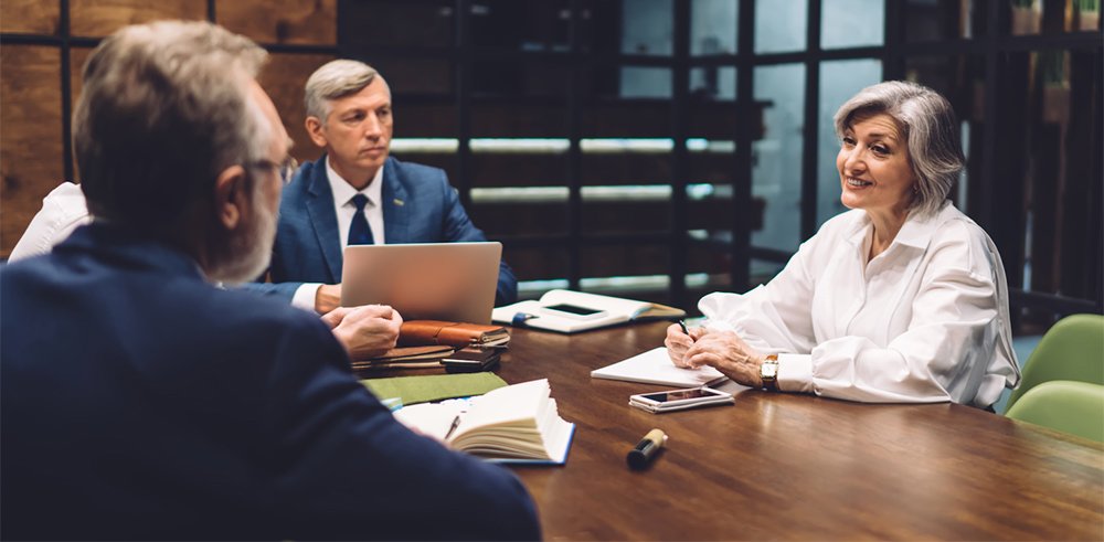 Consulting and testifying experts discussing litigation strategy in a conference room